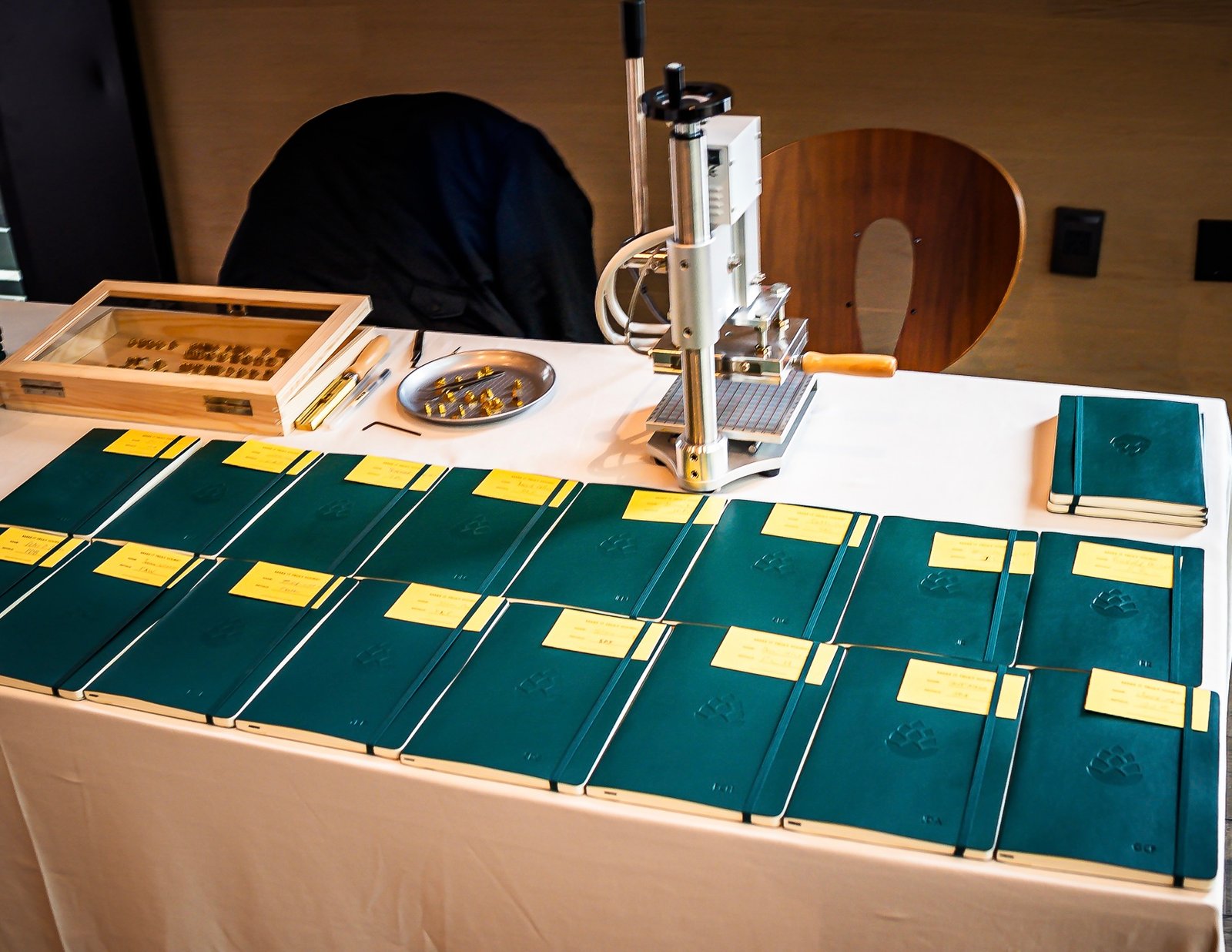 Onsite embossing setup at Napa Stanly Ranch for a tech financial conference, showcasing monogrammed leather cover notebooks for guests.