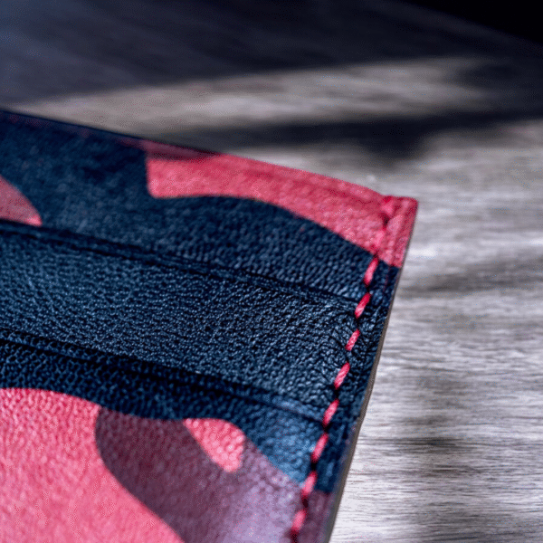 Close-up view of the bold red camouflage pattern on a handcrafted cardholder made from full-grain goat leather.