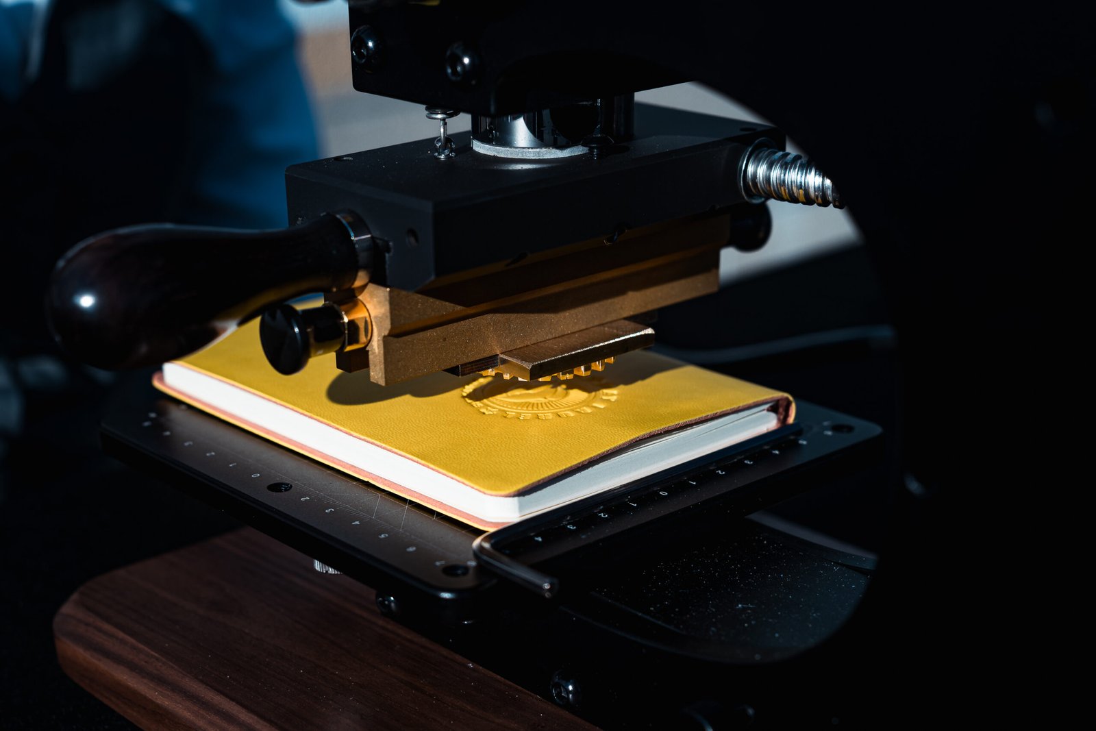 Custom logo embossing in progress at Bay Laurel School Dance event, with the logo being pressed into leather goods for guests.