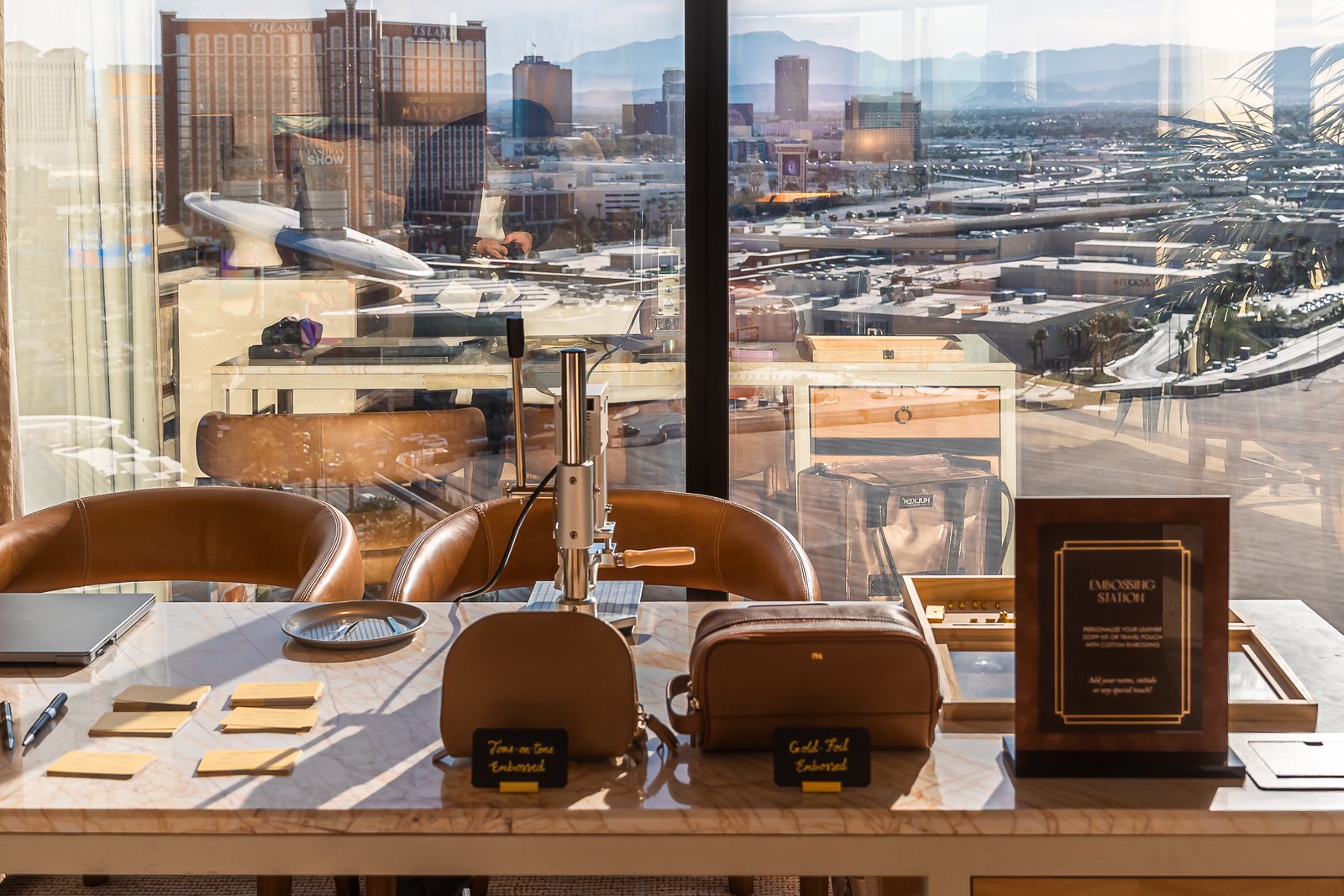Onsite leather personalization setup at Wynn Resort Las Vegas with Dopp kit and makeup bag, featuring tone-on-tone debossing and gold foil embossing.