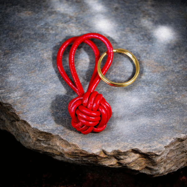 Handmade red leather monkey fist keychain with solid brass keyring, featuring a bold red color and traditional knot design.