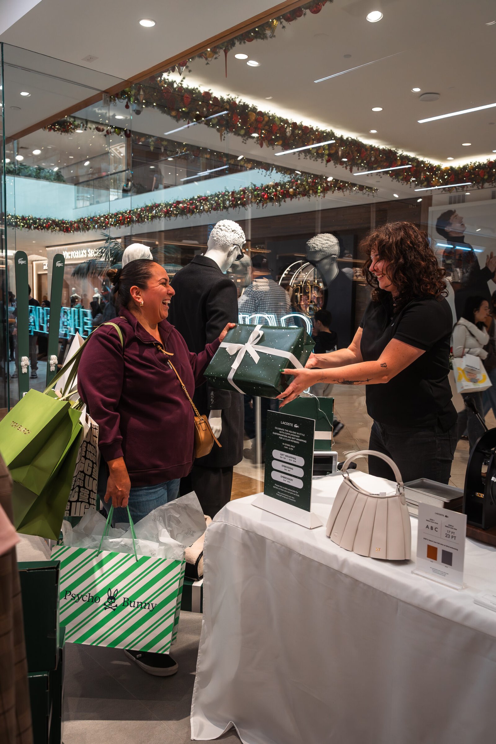 Two influencers capturing photos and videos of the onsite embossing station at Prime Video’s Maintenance Required premiere.