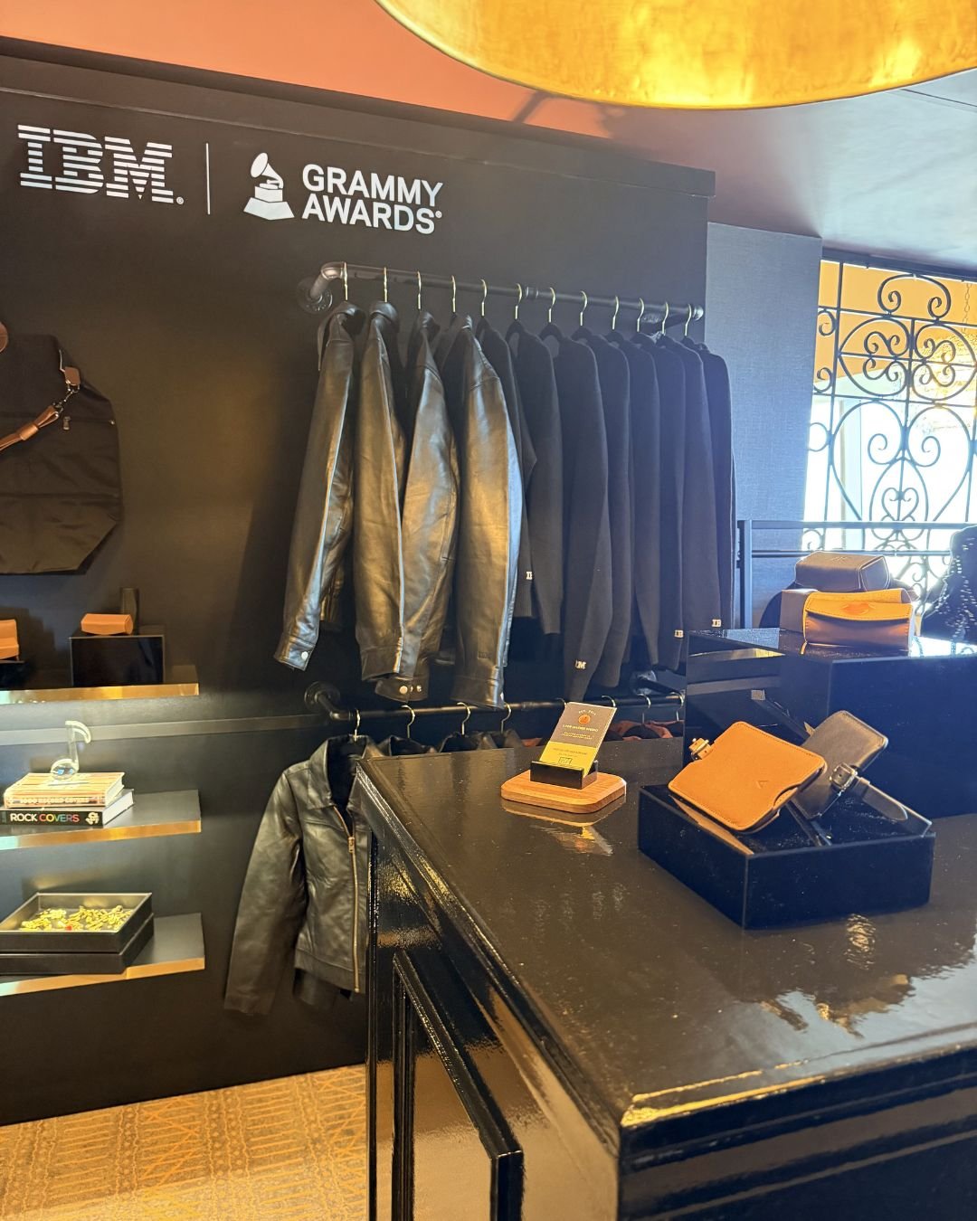 IBM Grammy Lounge Two white vegan leather license plate keychains from Prime Video’s Maintenance Required premiere, one embossed with KU in dark blue foil and the other showing the debossed “Maintenance Required” and “Prime Video” logos.